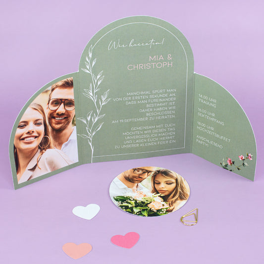 Geöffnete Hochzeitseinladung als Klappkarte mit zwei Fotos, Wunschtext, Tagesablauf und Herzdeko