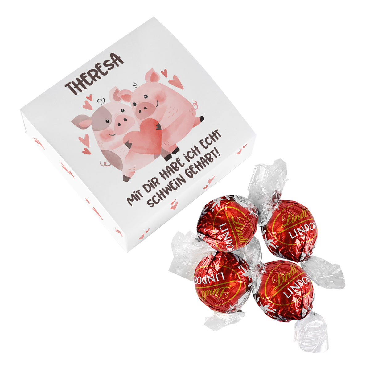Personalisierbare Geschenkbox mit Schweinchen-Motiv und dem Spruch „Mit dir habe ich echt Schwein gehabt!“ neben vier Lindor-Kugeln