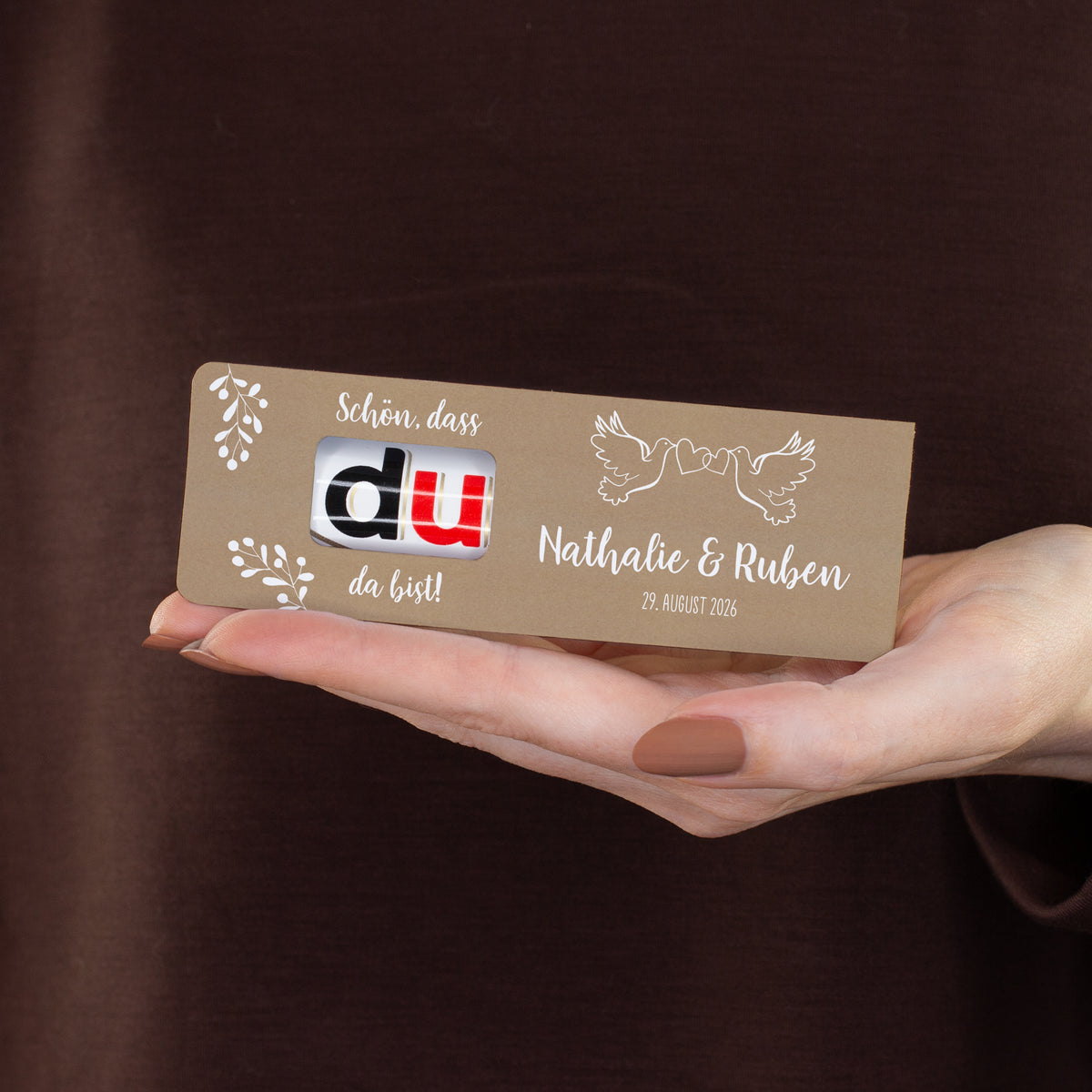 personalisierter duplo Riegel als Hochzeitsgastgeschenk wird in der Hand präsentiert