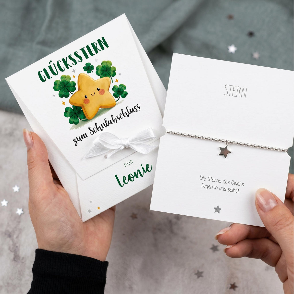 Glücksstern Geschenk zum Schulabschluss mit Name Leonie und silbernem Sternarmband in geöffneter Karte