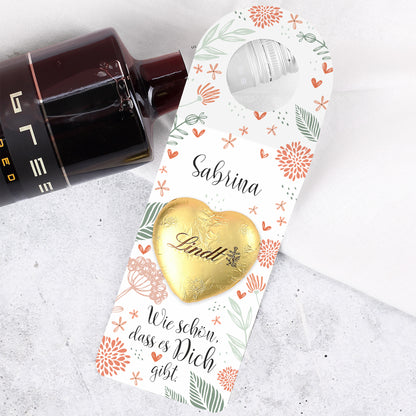 Goldenes Lindt Schokoladenherz auf dem Papieranhänger, hochwertig aufgeklebt und mittig platziert.