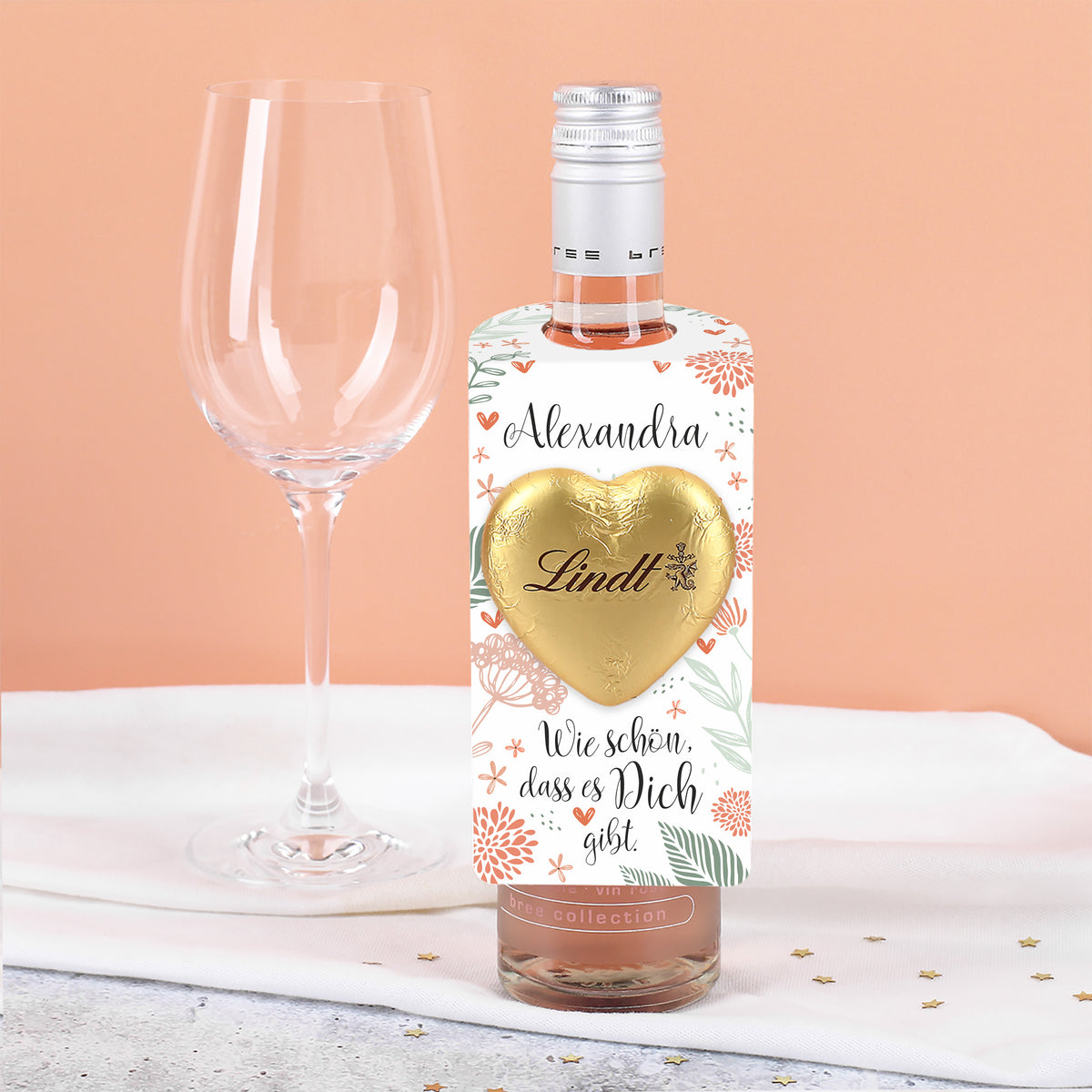 Kleiner Flaschenanhänger mit Lindt-Herz als Ergänzung zu einer Flasche BREE Roséwein.