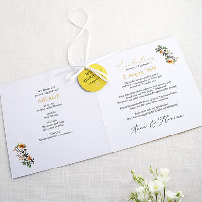 Einladungskarte zur Hochzeit mit Blütenkranz und rundem Anhänger