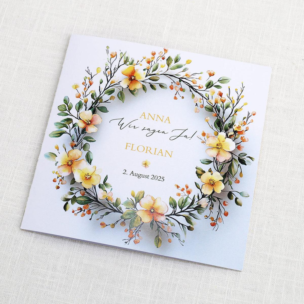 Einladungskarte zur Hochzeit mit Blütenkranz und rundem Anhänger