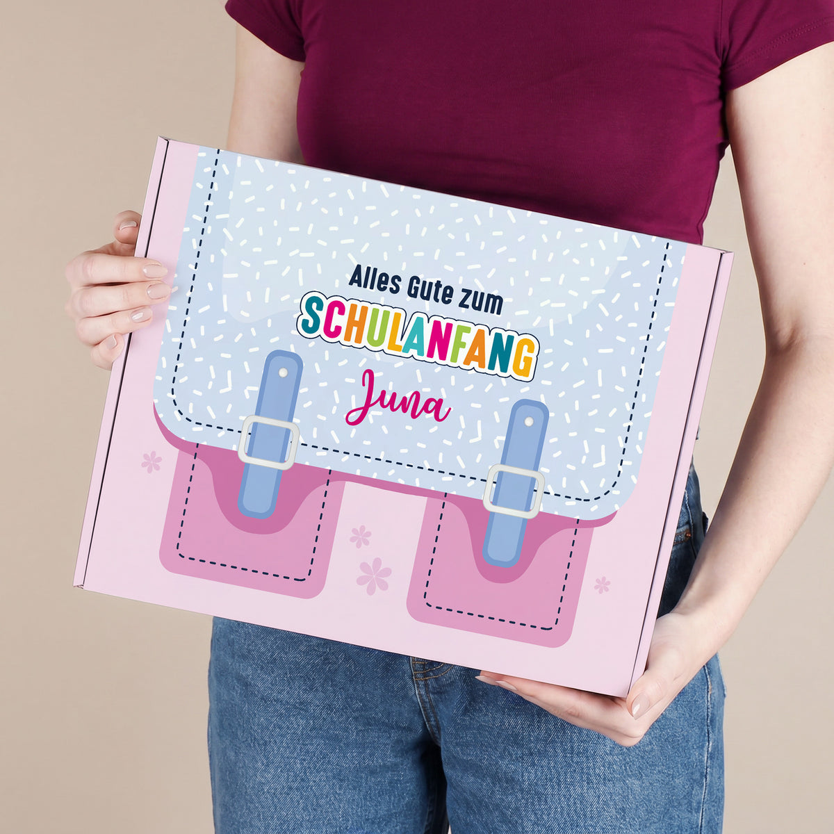 Große personalisierte Pappbox zur Einschulung in Rosa mit Schulranzen-Motiv und Name, von einer Person gehalten