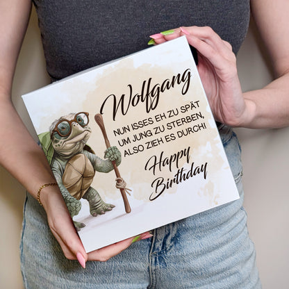 Person hält Kuchenbox mit Schildkrötenmotiv und Namen