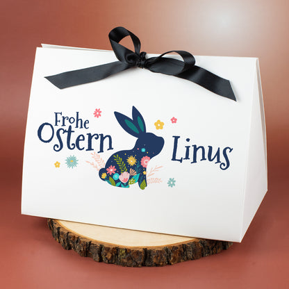Weiße Geschenkverpackung zu Ostern mit floralem Hasenmotiv und Name Linus