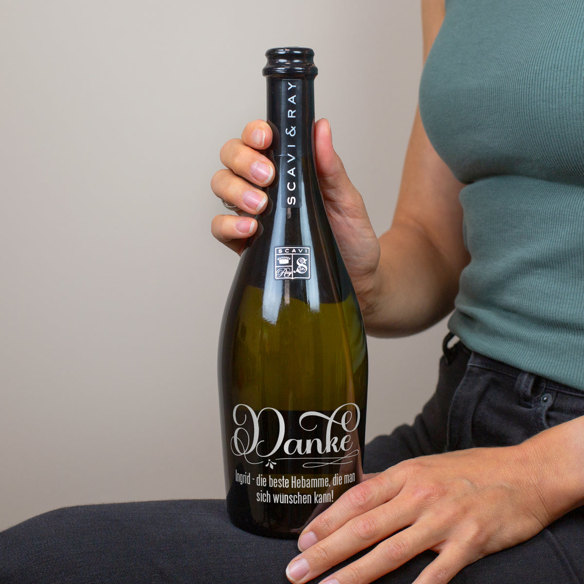 Person hält personalisierte Prosecco-Flasche mit Danke-Gravur und individuellem Text für eine Hebamme