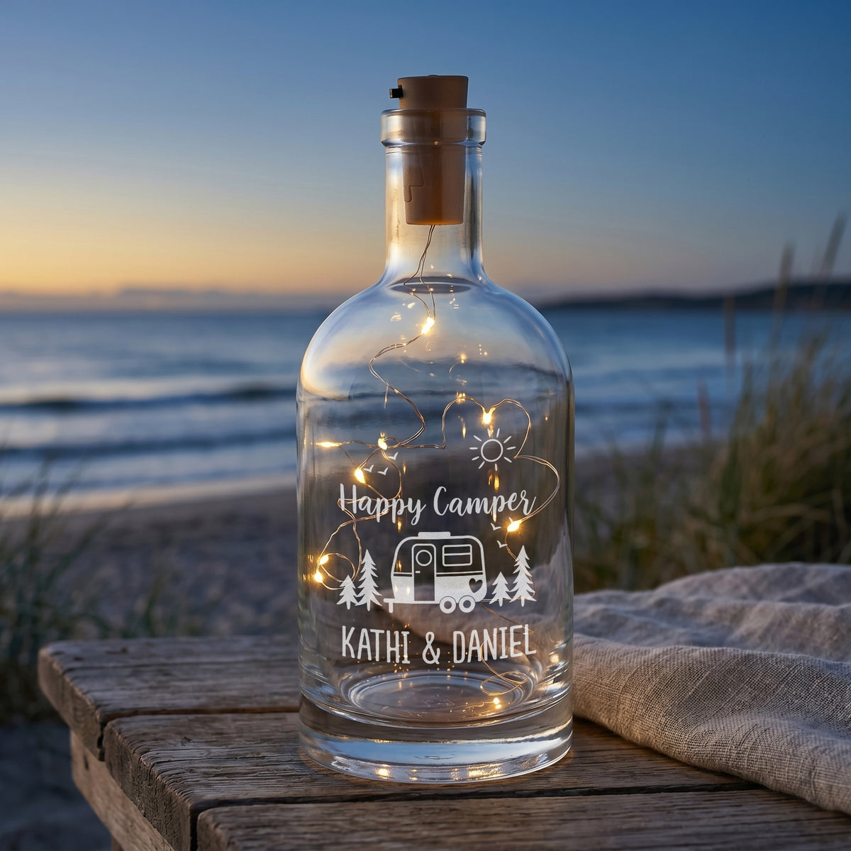 Personalisierte LED-Karaffe Happy Camper mit Wunschtext Kathi & Daniel am Strand bei Sonnenuntergang