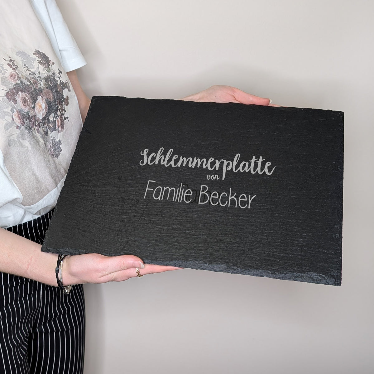 Schieferplatte mit Gravur „Schlemmerplatte von Familie Becker“, in Händen gehalten, zur Größenansicht