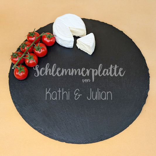 Runde Schieferplatte mit Gravur „Schlemmerplatte“ und zwei Namen, serviert mit Camembert und Tomaten