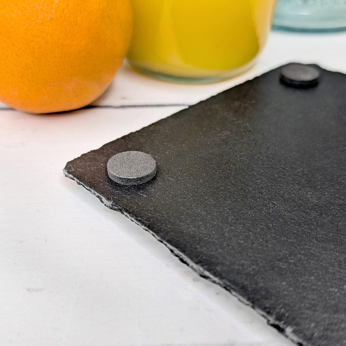 Detailansicht der Unterseite eines gravierten Schiefer-Untersetzers mit rutschfesten Gummifüßen
