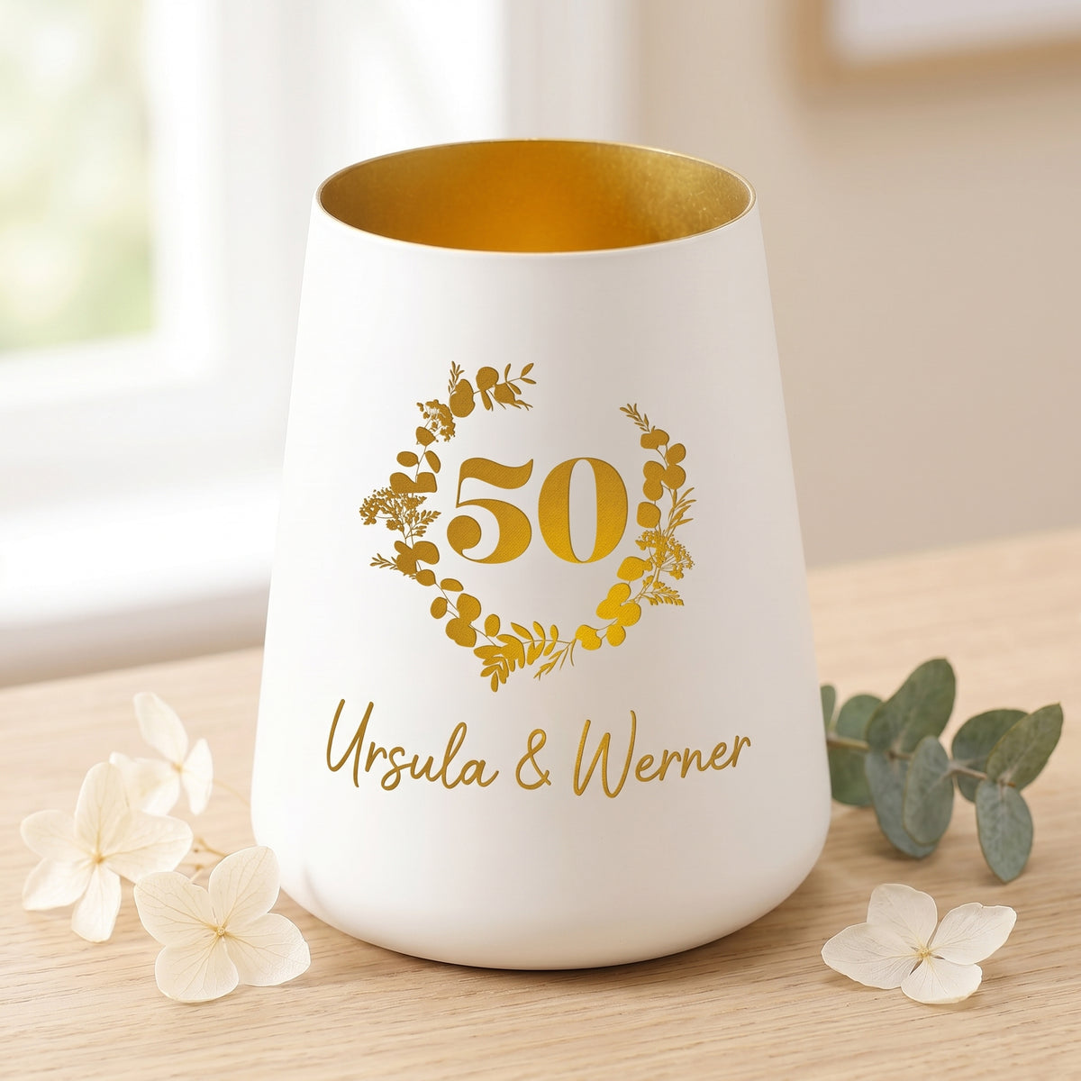 Windlicht zur Goldenen Hochzeit mit Namen Ursula und Werner, dekoriert mit weißen Blüten auf hellem Holz