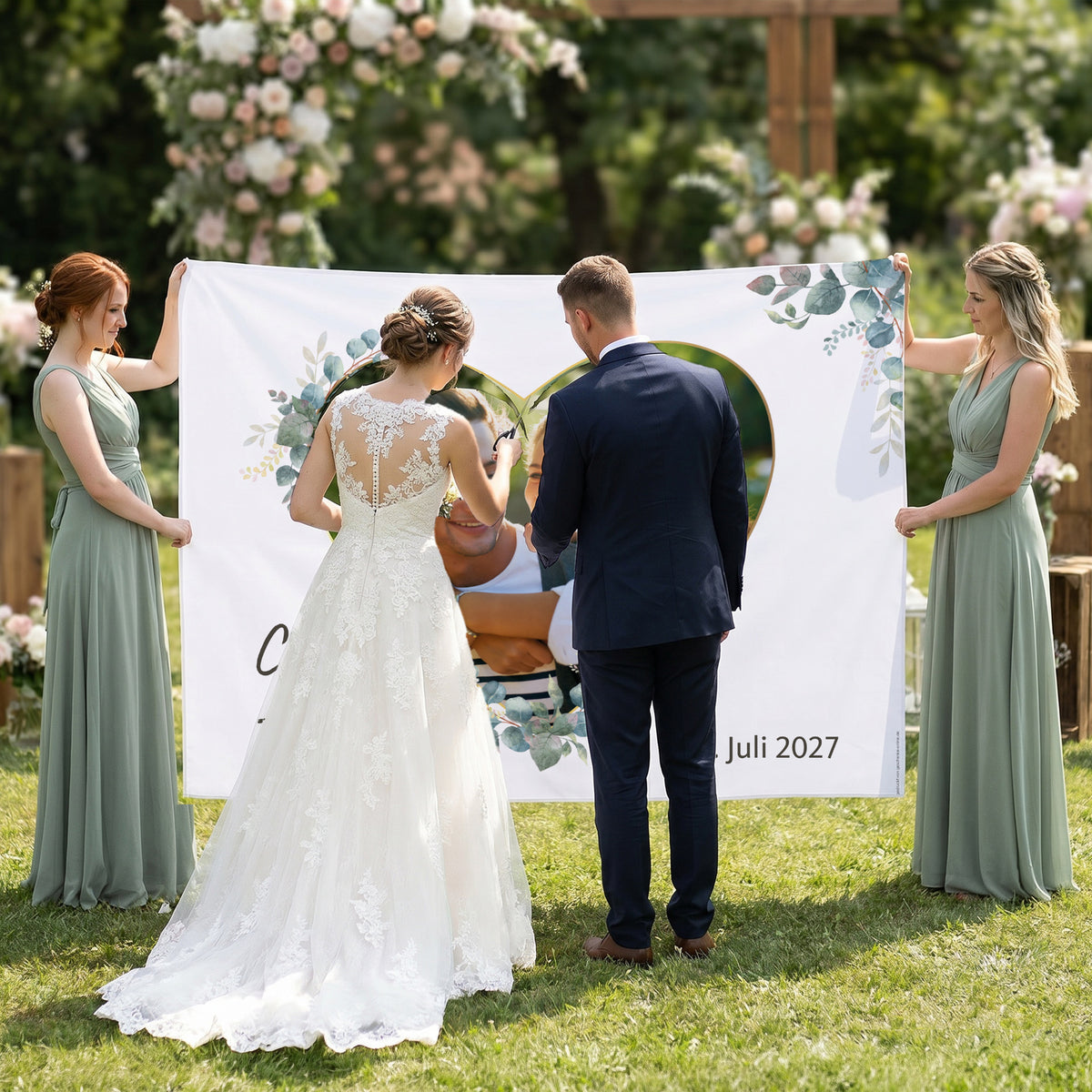 Brautpaar schneidet Herzmotiv aus Hochzeitsbanner mit Foto von Clara und Tobias