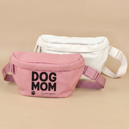Personalisierte Dog Mom Bauchtasche in Rosa mit Name Larissa, daneben beige Variante auf beigem Hintergrund