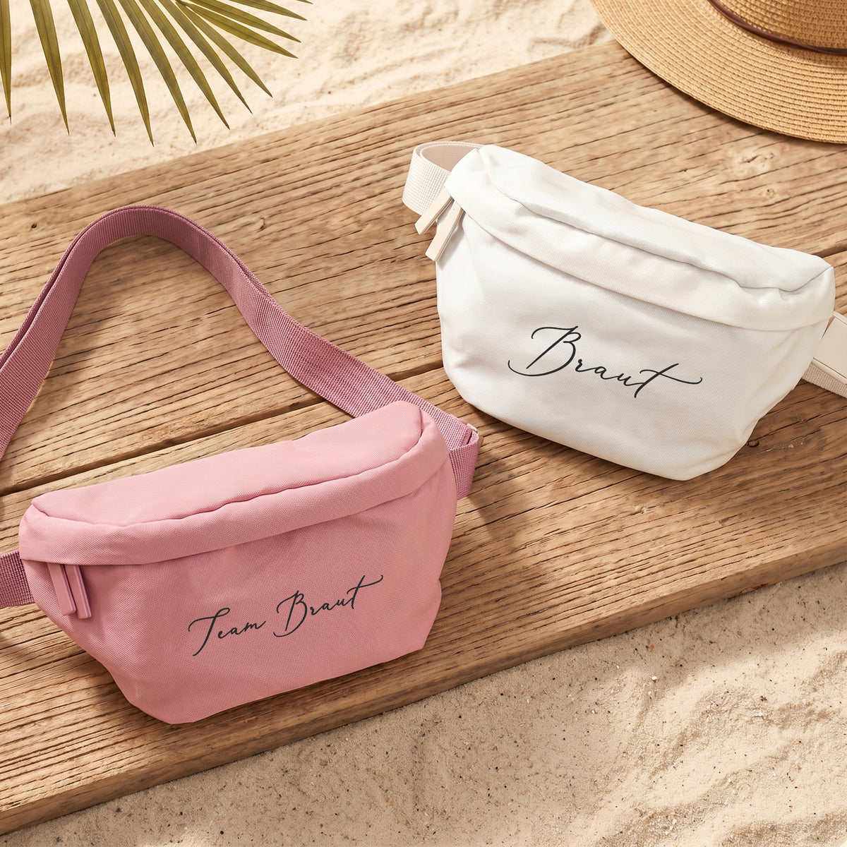 Rosa Bauchtasche mit Wunschtext Team Braut und cremefarbene Tasche mit Braut-Schriftzug auf Holzuntergrund