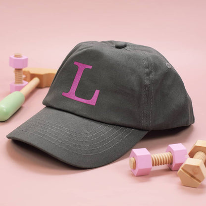 Graues Kinder-Basecap mit Initiale in rosa bestickt