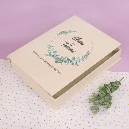 Personalisierte Erinnerungsbox zur Hochzeit mit Eukalyptus-Kranz, Namen und Wunschtext auf beiger Box in Buchform