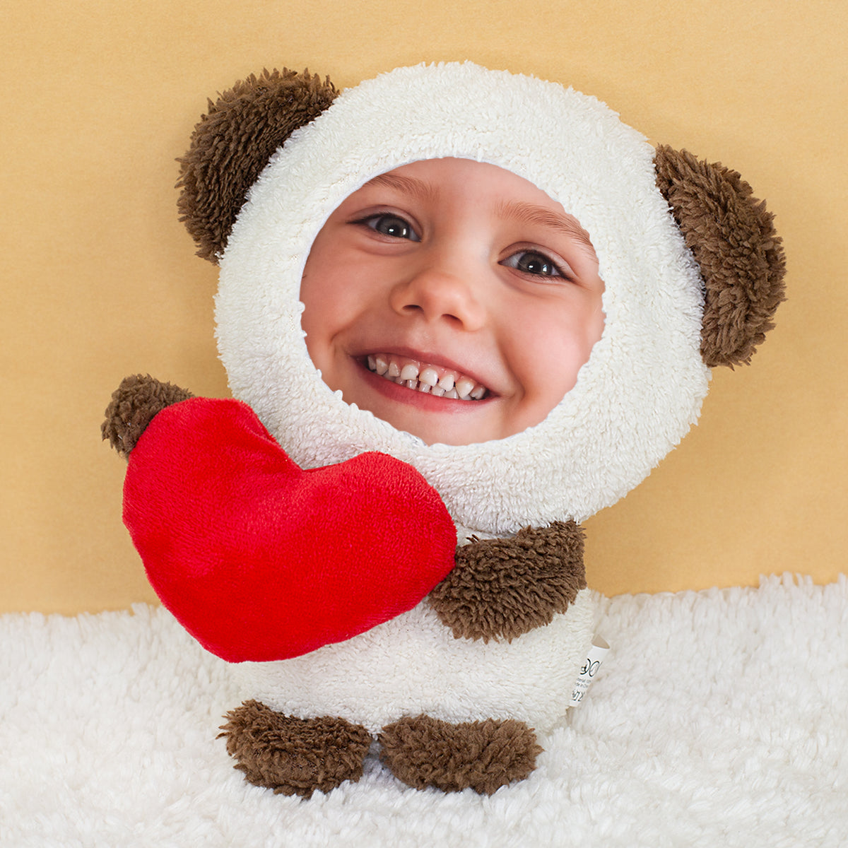 Fototeddy mit Kinderfoto als Gesicht und rotem Herz auf heller Kuscheldecke