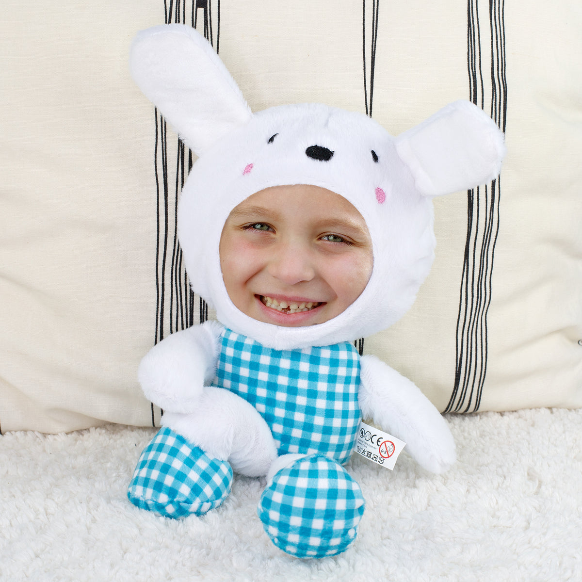 Personalisierter Fotohase mit blau kariertem Outfit sitzend auf flauschiger Decke