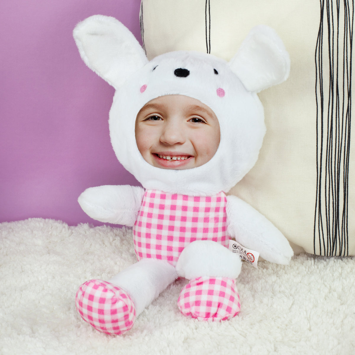 Personalisierter Fotohase mit rosa kariertem Outfit sitzend auf weicher Decke