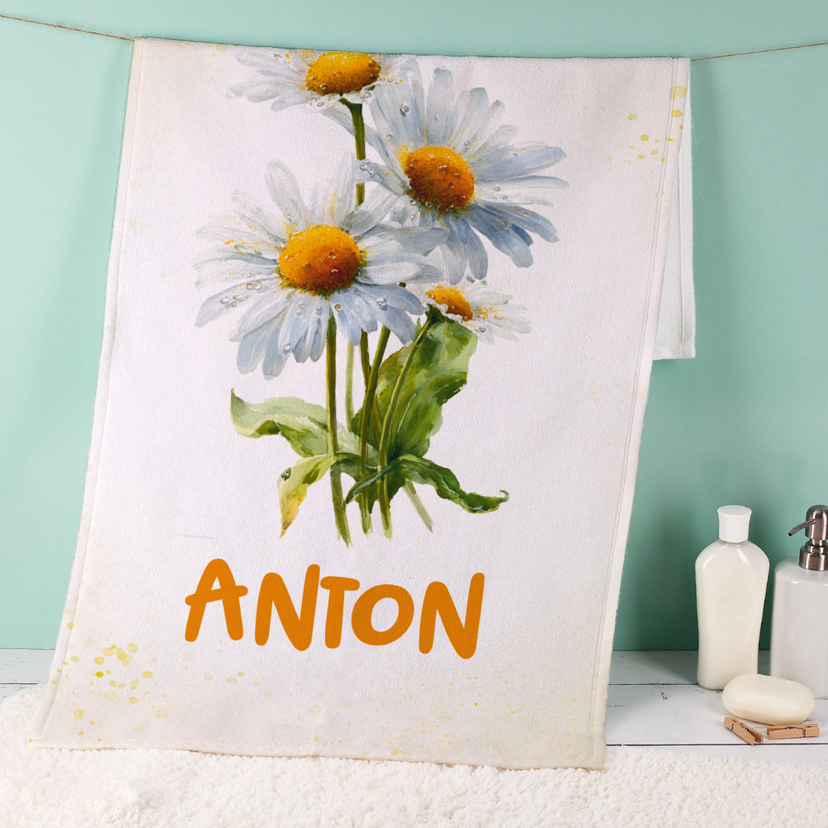 Weißes Handtuch mit Margeriten-Geburtsblume und Name Anton im Badezimmer
