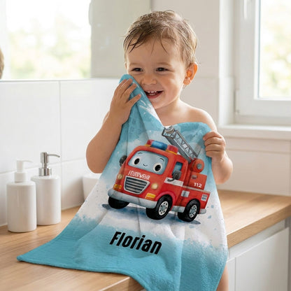 Kind hält personalisiertes Feuerwehr Handtuch mit Feuerwehrauto Motiv und Name Florian im Badezimmer