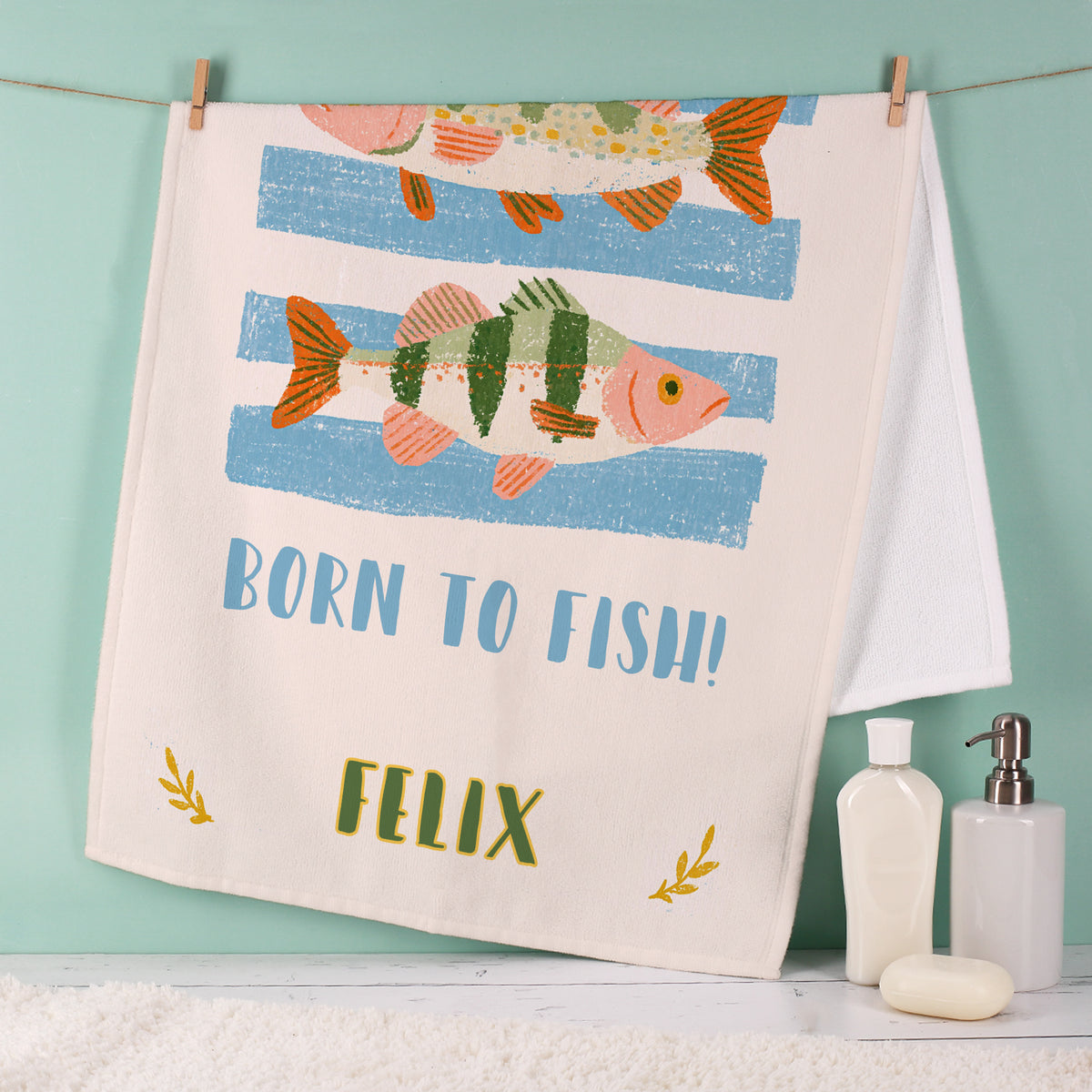 Handtuch für Angler mit bunten Fischillustrationen, Spruch Born to Fish und personalisiertem Namen Felix im Badezimmer