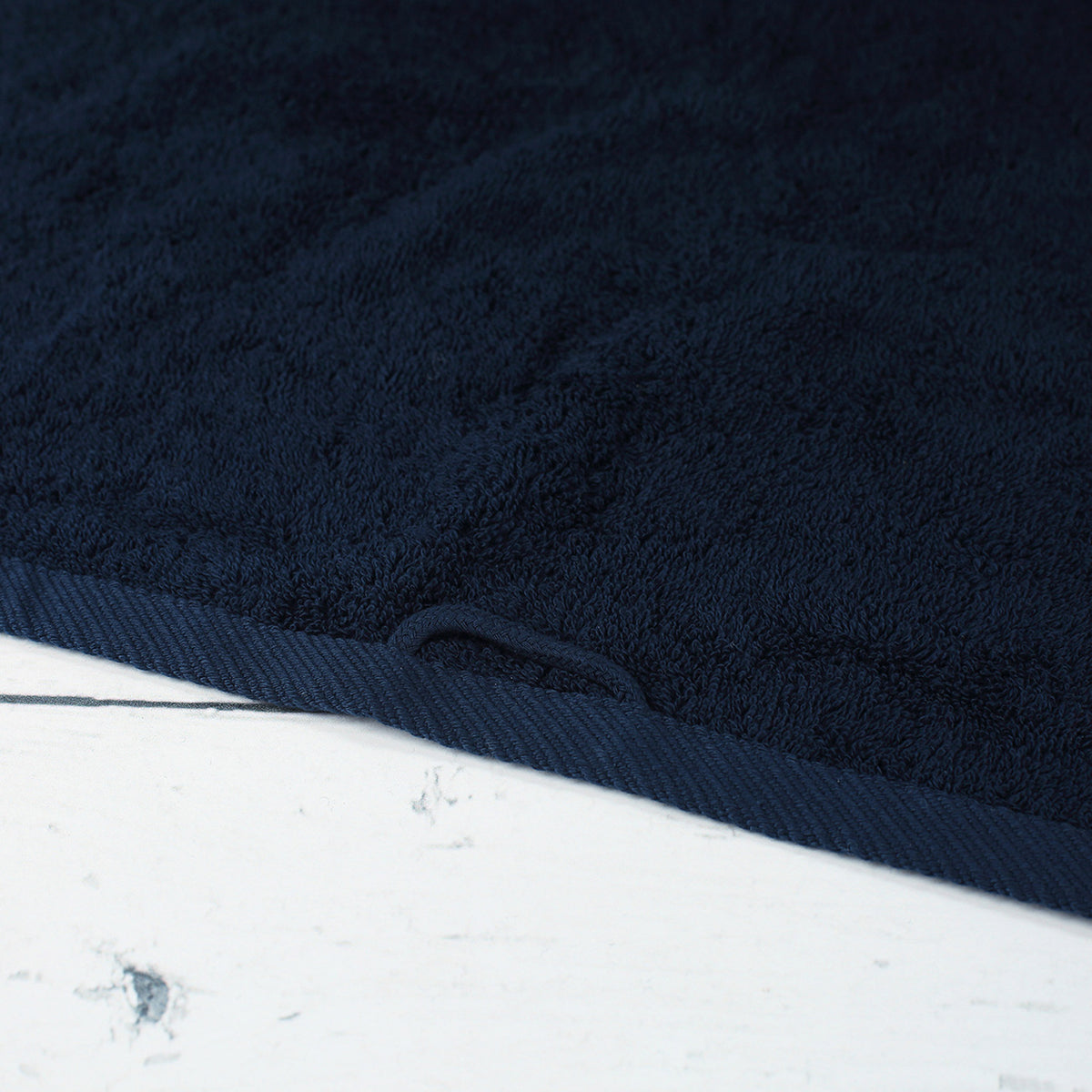 Detailaufnahme von nachtblauem Handtuch aus Baumwolle mit Aufhängeschlaufe und strukturierter Frottier-Oberfläche