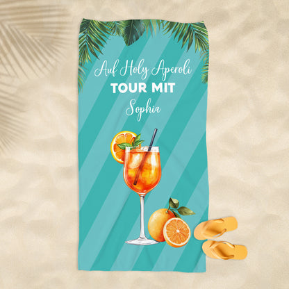 Badetuch mit Aperol-Design am Strand ausgebreitet, sommerliches Motiv mit personalisierter Beschriftung.
