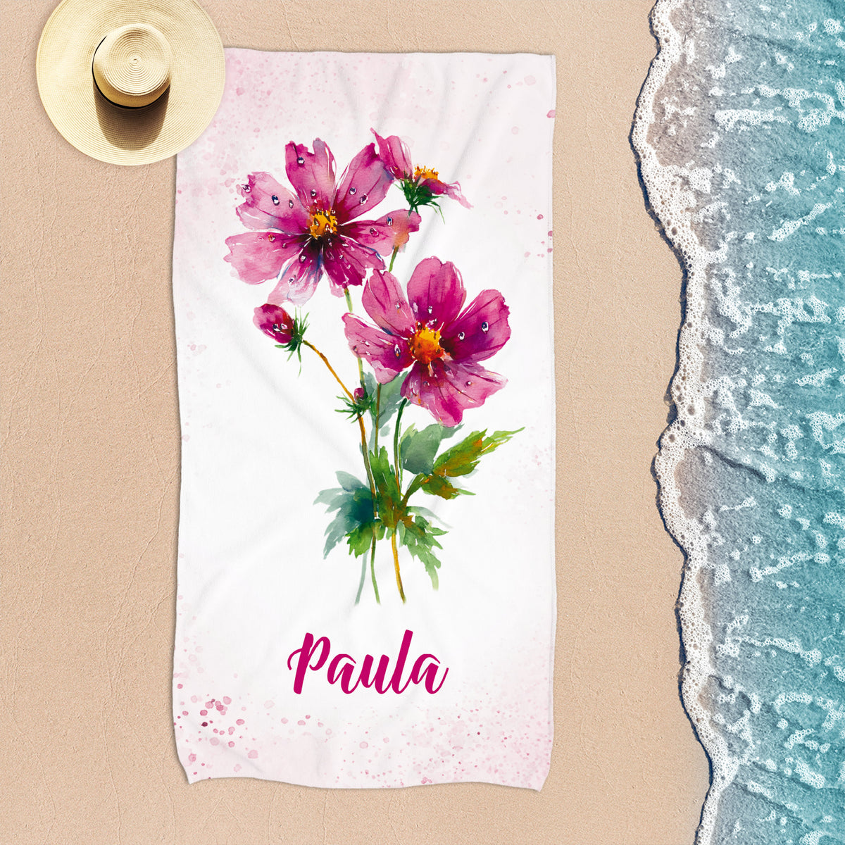 Personalisiertes Strandtuch mit rosa Geburtsblumen und Name Paula am Strand von oben