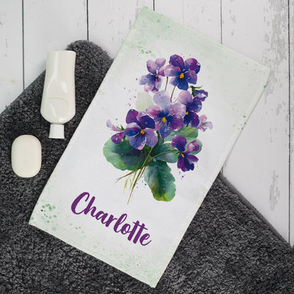 Gästehandtuch mit violettem Veilchen-Motiv und Name Charlotte im Badezimmer