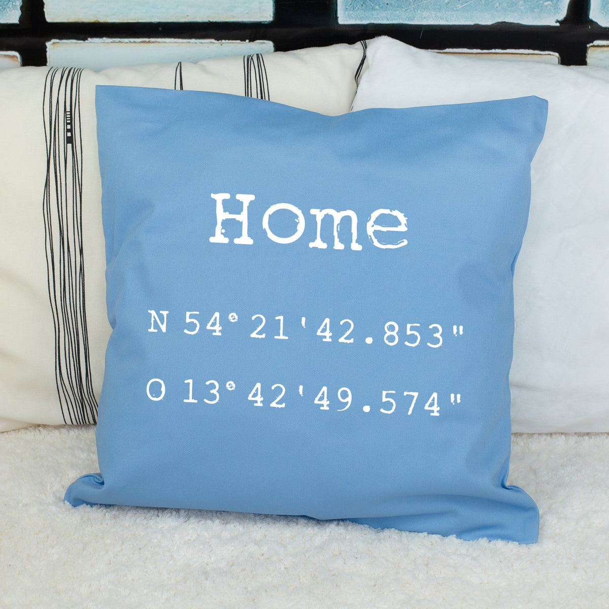 Blaues Kissen mit Wunschtext Home und Koordinaten als personalisiertes Geschenk