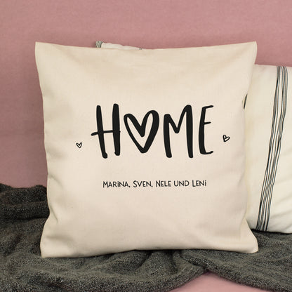 Naturfarbenes HOME Kissen mit Wunschtext Marina Sven Nele und Leni auf dem Sofa