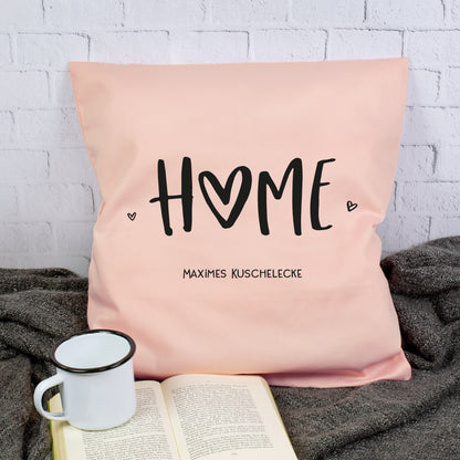 Rosa personalisiertes HOME Kissen mit Wunschtext Maximes Kuschelecke neben Buch und Tasse