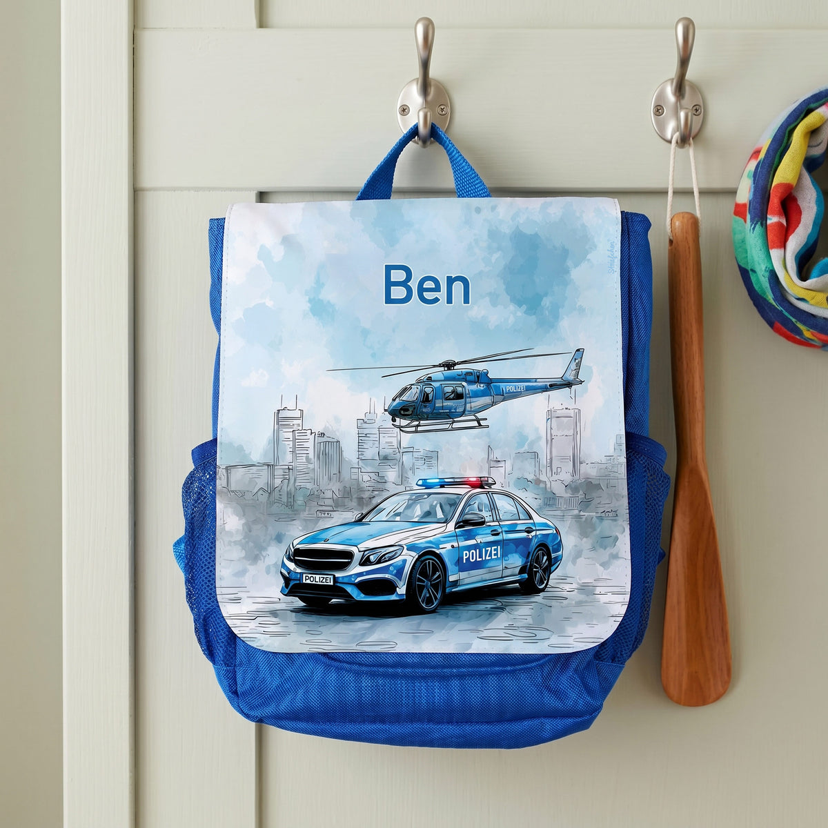 Personalisierter Kindergartenrucksack mit Name Ben und Polizei-Motiv an einer Garderobe