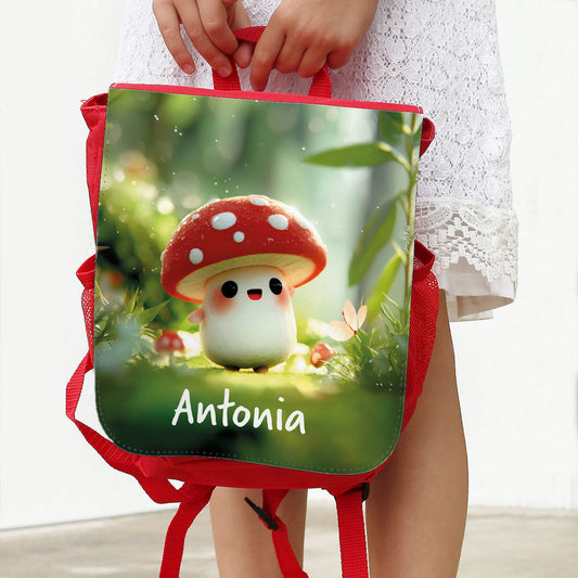 Personalisierter roter Kindergartenrucksack mit Name Antonia und niedlichem Glückspilz-Motiv in Kinderhänden
