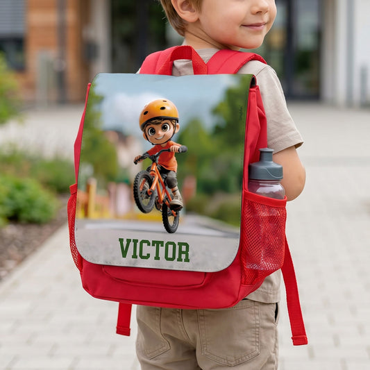 Personalisierter roter Kindergartenrucksack für Jungen mit Fahrrad-Motiv und Name Victor, getragen von einem Kind