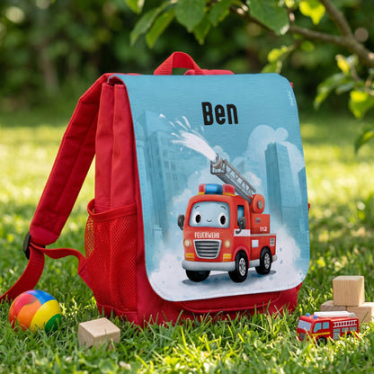 Personalisierter roter Kindergartenrucksack mit Feuerwehr-Motiv und Name Ben auf einer Wiese fotografiert