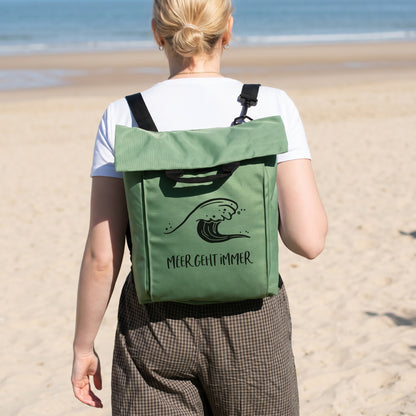Jadegrüner Rucksack mit Wellenmotiv und Wunschtext Meer geht immer am Strand getragen