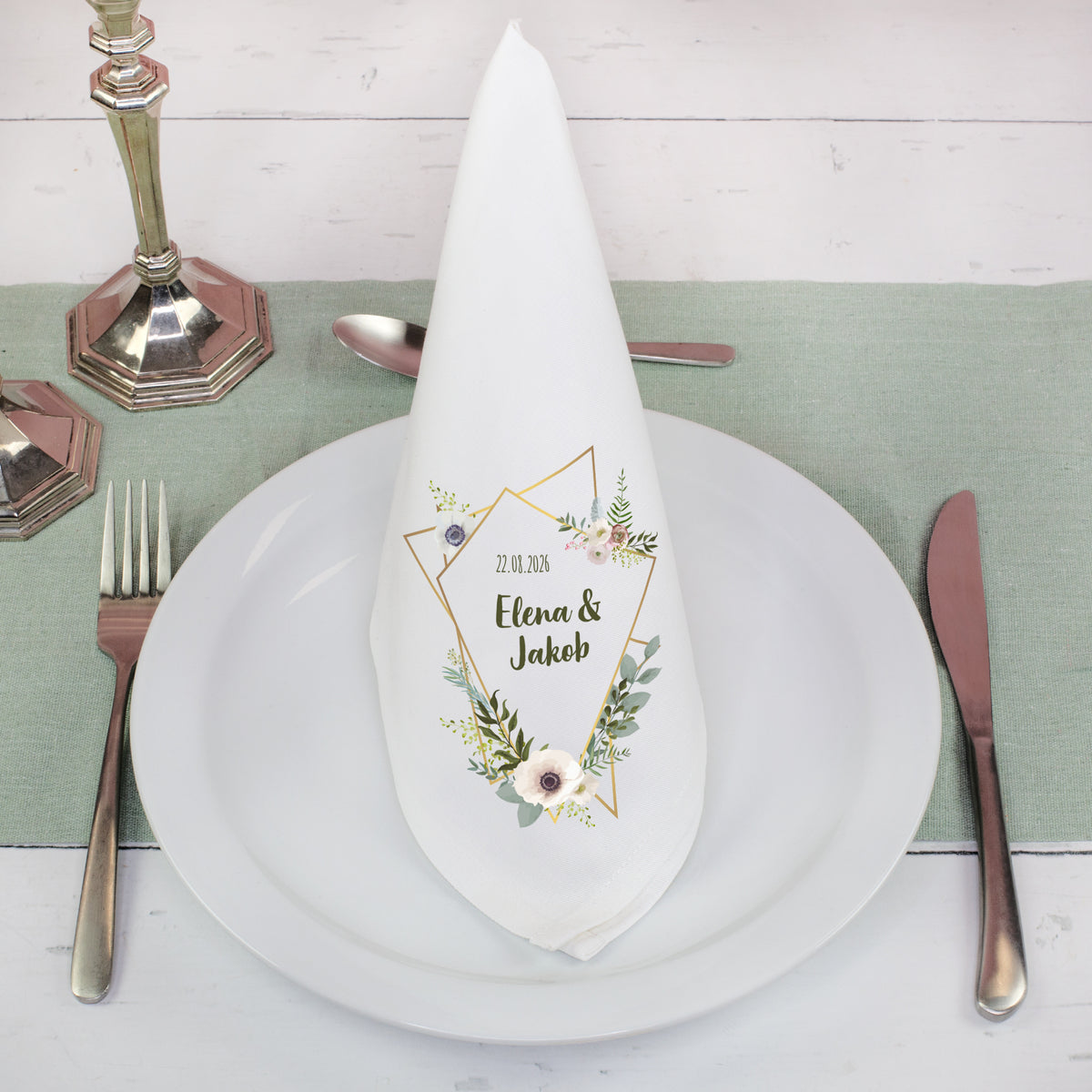 Weiße Stoffserviette mit Blumenmotiv und Namen als Tischdeko zur Hochzeit