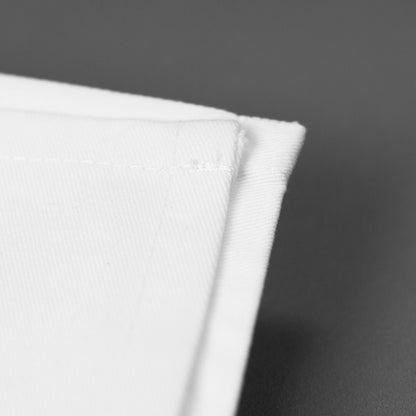 Detailaufnahme der hochwertigen Stoffkante einer weißen Serviette