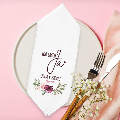 Personalisierte Stoffserviette Hochzeit Wir sagen Ja mit Blumenmotiv Namen und Datum auf Teller dekoriert