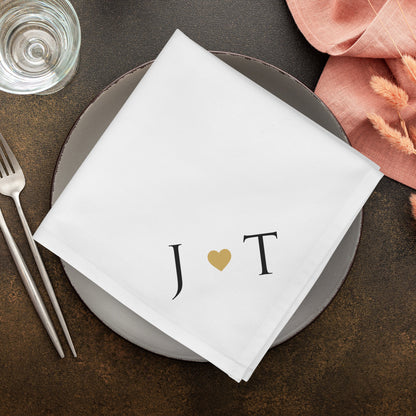 Weiße Hochzeitsserviette mit Initialen J und T und Herzmotiv als moderne Tischdekoration