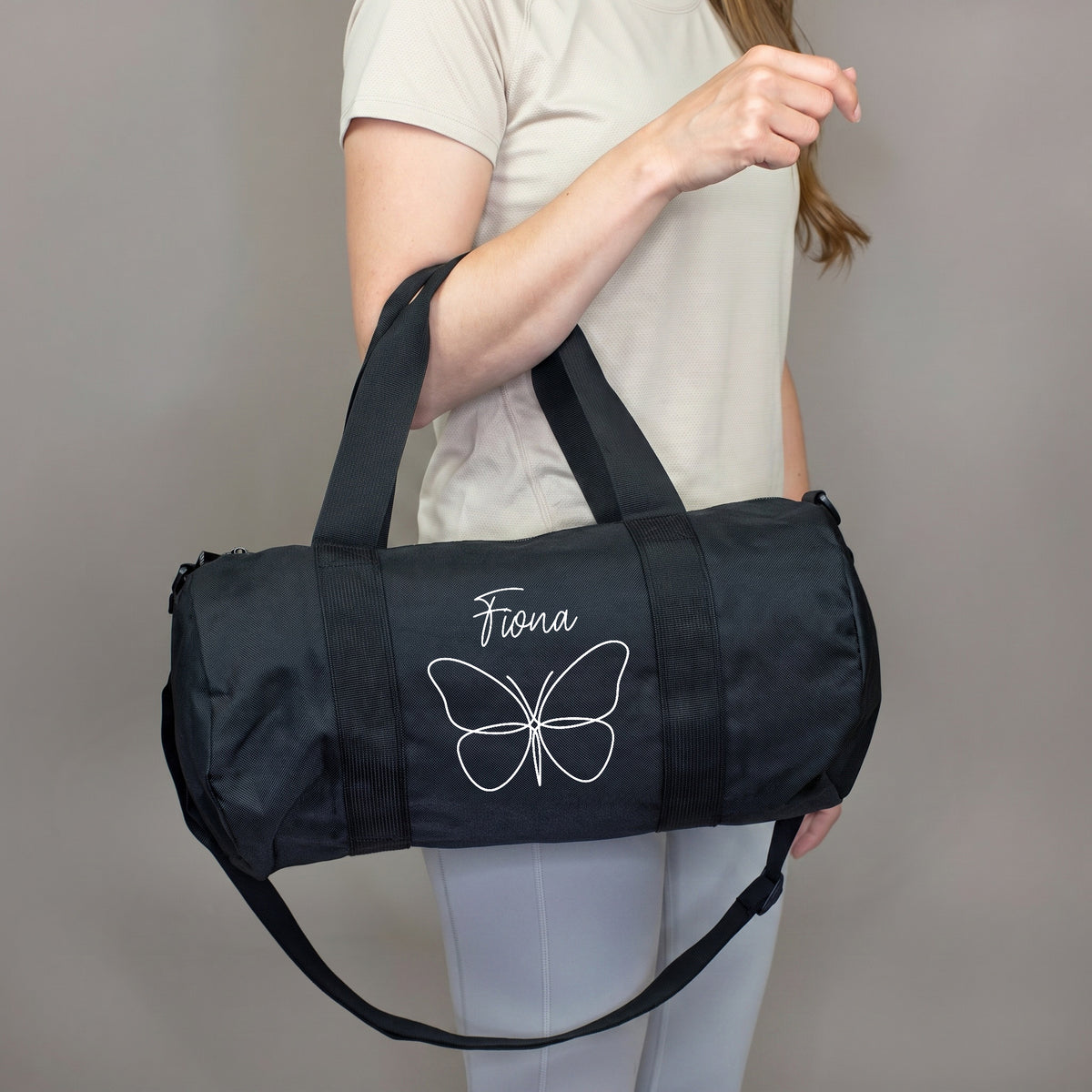 Personalisierte Sporttasche mit Schmetterling und Name Fiona über der Schulter getragen