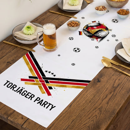 Fußball Tischläufer mit Wunschtext Torjäger Party auf gedecktem Holztisch mit Bierglas und Snacks