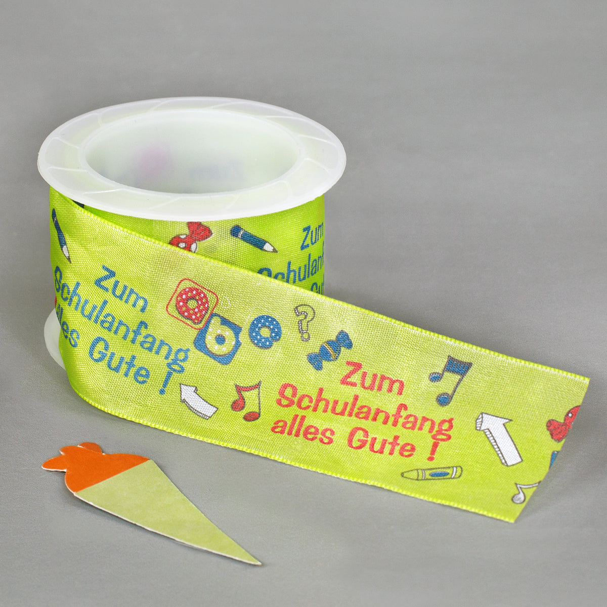 Nahaufnahme Geschenkband Schulanfang auf Rolle mit Schulmotiven, Schultüte und bunter Aufschrift