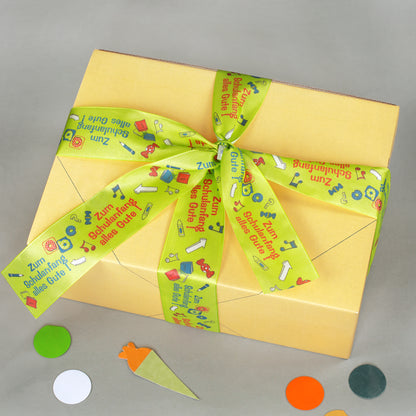 Gelbe Geschenkbox von oben mit Schleife aus Geschenkband für Schulanfang und Einschulung