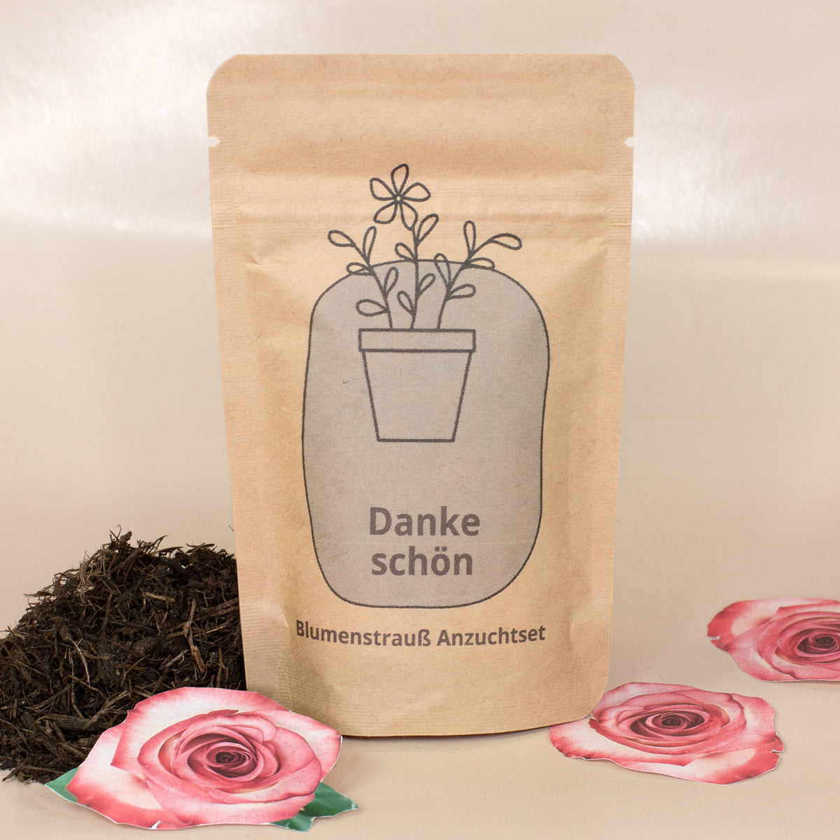 Danke schön Anzuchtset mit Blumensamen neben Erde und Rosenmotiven als kleine Geschenkidee