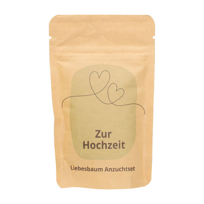Freigestelltes Zur Hochzeit Anzuchtset in brauner Kraftpapiertüte mit Herzmotiv und Schriftzug Liebesbaum Anzuchtset